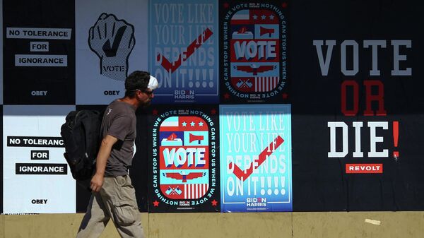 Мужчина проходит мимо предвыборных плакатов в городе Фениксе штата Аризона в США