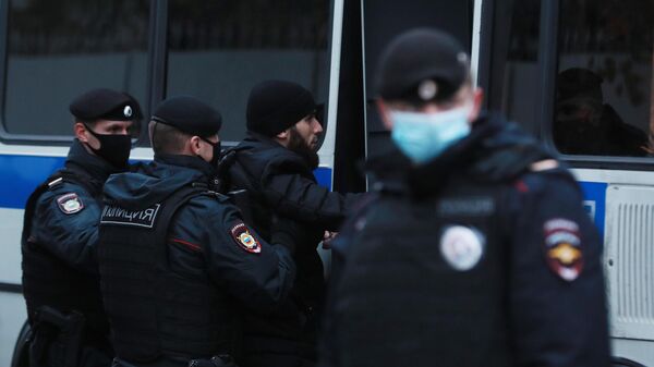 Сотрудники полиции задерживают участника акции протеста около посольства Франции в Москве