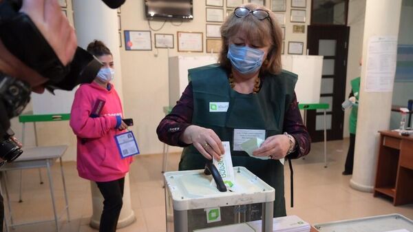 Женщина принимает участие в голосовании на парламентских выборах в Грузии на одном из избирательных участков в Тбилиси
