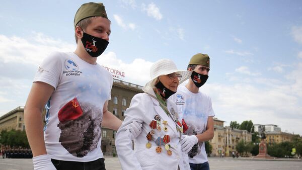 Волонтеры сопровождают ветерана Великой Отечественной войны на военном параде в ознаменование 75-летия Победы в Великой Отечественной войне 1941-1945 годов в Волгограде