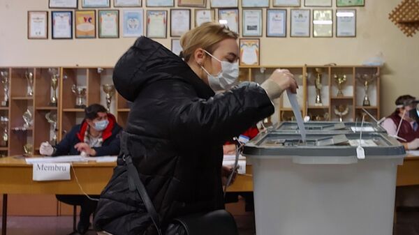 Женщина голосует на всеобщих выборах президента Молдавии на одном из участков в Кишиневе.