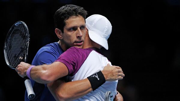 Poland's Lukas Kubot (R) and Brazil's Marcelo Melo (L) embrace as they celebrate their win over Croatia's Ivan Dodig and Slovakia's Filip Polasek in their men's doubles round-robin match on day one of the ATP World Tour Finals tennis tournament at the O2 Arena in London on November 10, 2019. (Photo by Adrian DENNIS / AFP)