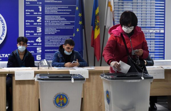Женщина голосует на всеобщих выборах президента Молдавии на одном из участков в Кишиневе