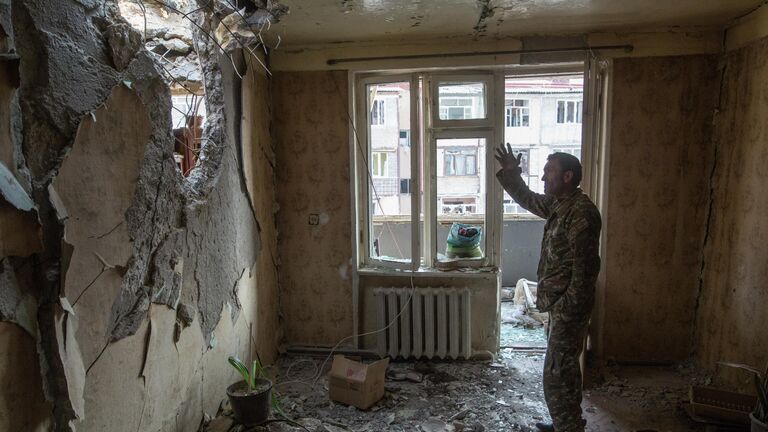 Мужчина в разрушенной квартире в Степанакерте
