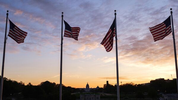 Флаги США около монумента первому президенту Джорджу Вашингтону в Вашингтоне