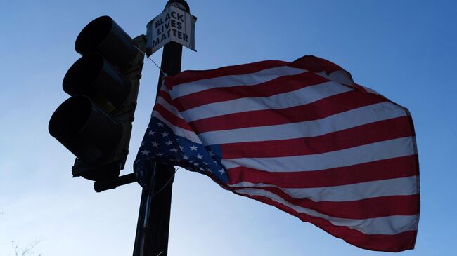 Флаг Соединенных Штатов Америки на светофоре на одной из улиц в Вашингтоне в преддверии выборов президента США