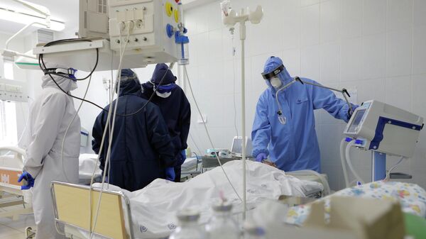 Медицинские работники и пациент в реанимационной палате в ковид-госпитале