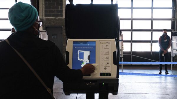Избиратель опускает бюллетень в урну для голосования на одном из избирательных участков в Вашингтоне