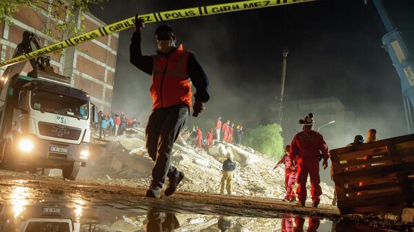 Спасатели ищут выживших среди обломков разрушенного здания в районе Байракли в Измире 