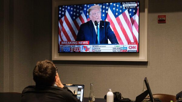 Мужчина смотрит новости о президентских выборах 2020 года в одном из отелей в Вашингтоне