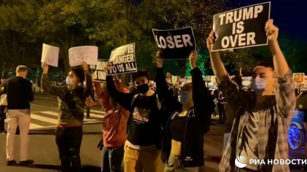 Противники Трампа танцуют и стоят с плакатам возле Белого дома 