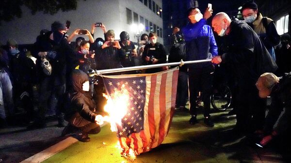 Протестующие в Портленде поджигают американский флаг
