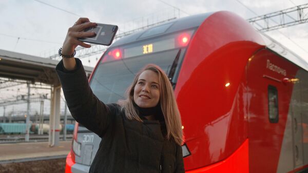 Девушка делает селфи у скоростного поезда Ласточка перед отправлением первого рейса с железнодорожного вокзала Челябинска в Магнитогорск