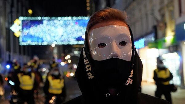 Участник Марша миллиона масок на Оксфорд-стрит в Лондоне