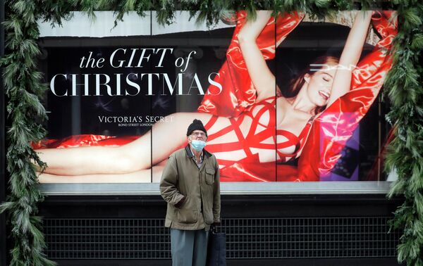 Мужчина перед рекламой закрытого магазина в Лондоне
