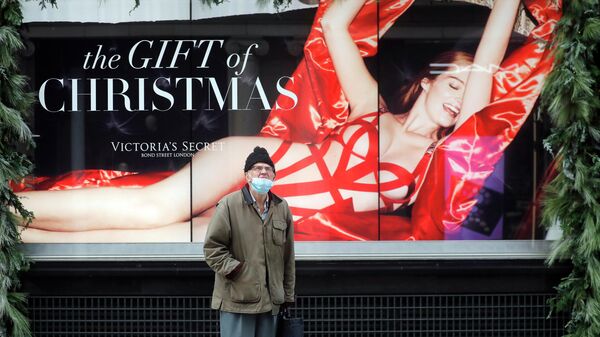 Мужчина перед рекламой закрытого магазина в Лондоне