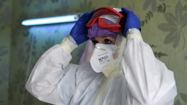 Медицинский работник переодевается в защитный костюм в ковидном госпитале на базе санатория Прибой в Евпатории
