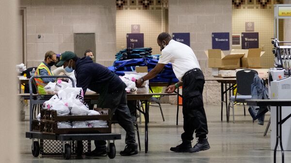 Рабочие перевозят коробки с бюллетенями внутри Конгресс-центра в Филадельфии