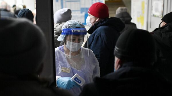 Измерение температуры людям при входе в поликлинике городской больницы №2 в Омске.