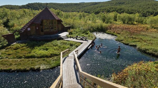 Туристы купаются в Налычевских термальных источниках в природном парке Вулканы Камчатки