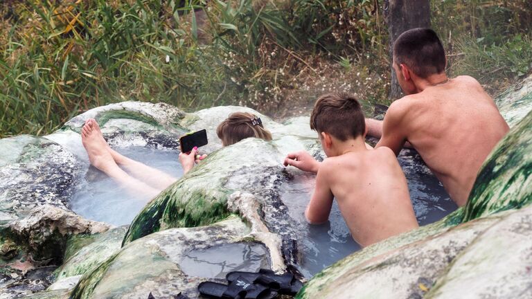 Люди купаются в открытых купальнях с водой из минерального источника в Пятигорске