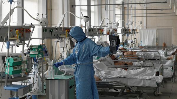 Медицинский работник и пациенты в отделении интенсивной терапии ковид-госпиталя, организованного в городской клинической больнице No15 имени О. М. Филатова в Москве