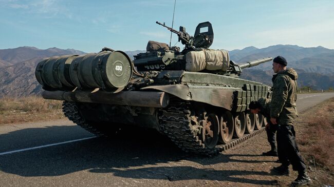 Военнослужащие российских миротворческих сил рядом с танком недалеко от границы с Арменией