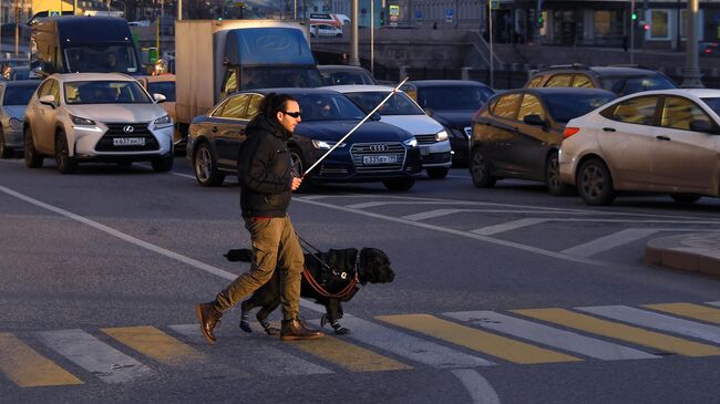 Мужчина переходит дорогу на одной из улиц Москвы