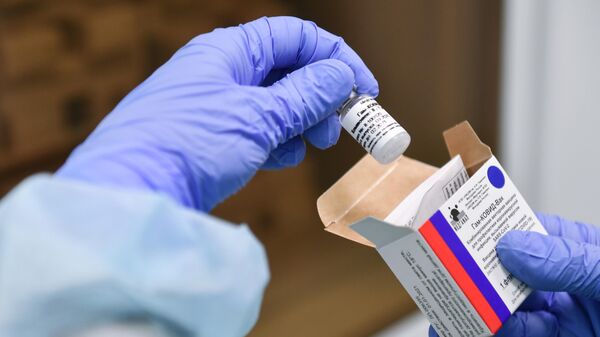 Медсестра держит ампулу с вакциной от коронавируса