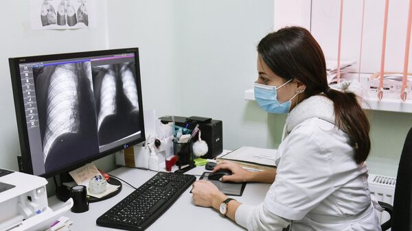 Врач-рентгенолог изучает рентгенографические снимки грудной клетки пациента
