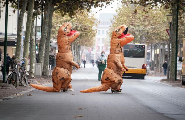 Участники карнавала в костюмах динозавров в Майнце, Германия 