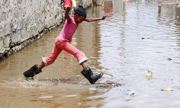 Ребенок прыгает через паводковые воды в городе Найваша, округ Накуру, Кения