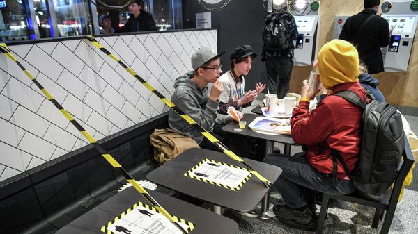 Столики с ограничительной лентой в ресторане быстрого питания в Стокгольме