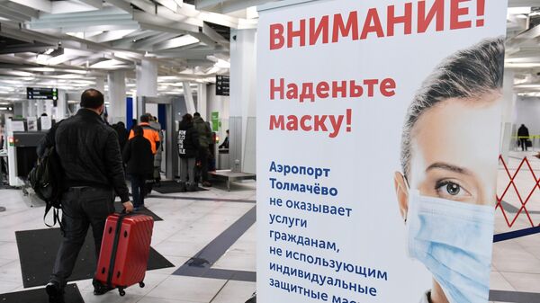 Плакат с надписью Внимание! Наденьте маску! в международном аэропорту Толмачёво в Новосибирске