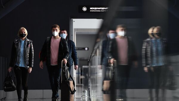 Пассажиры в защитных масках в международном аэропорту Толмачёво в Новосибирске