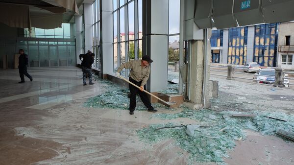 Мужчины убирают разбитые стекла в центре Степанакерта