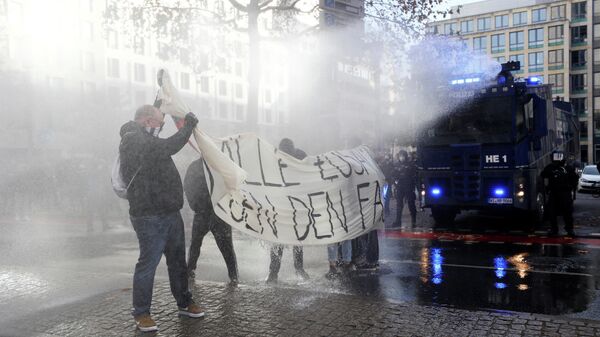 Полицейские используют водометы против участников акции протеста во Франкфурте, Германия