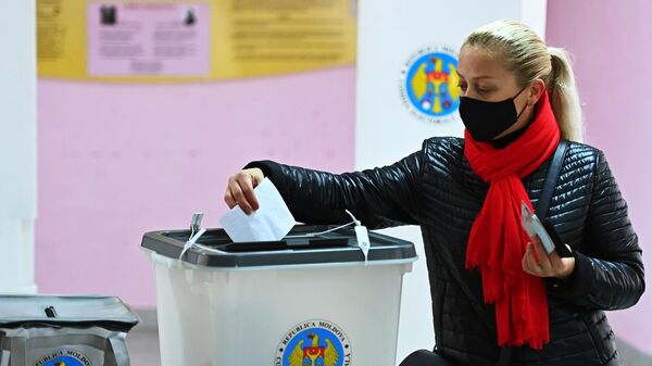 Женщина голосует во время второго тура на выборах президента Молдавии на избирательном участке в Кишиневе
