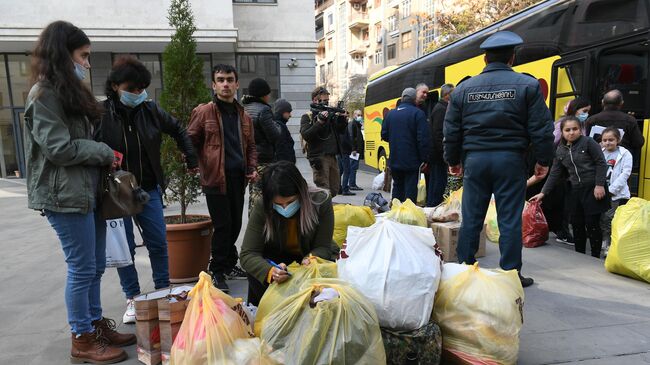 Беженцы из Нагорного Карабаха садятся в салон автобуса в Ереване во время возвращения домой в Степанакерт