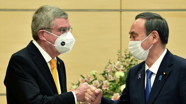 Премьер-министр Японии Ёсихидэ Суга (справа) и президент Международного олимпийского комитета (МОК) Томас Бах