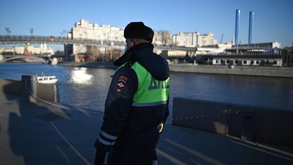 Сотрудник ГИБДД на месте падения автомобиля в Москва-реку на Пречистенской набережной
