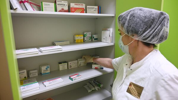 Медицинская сестра раскладывает лекарства для пациентов с COVID-19