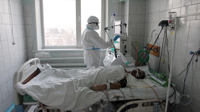 Медицинский работник и пациент в отделении интенсивной терапии ковид-госпиталя в Новоалтайске