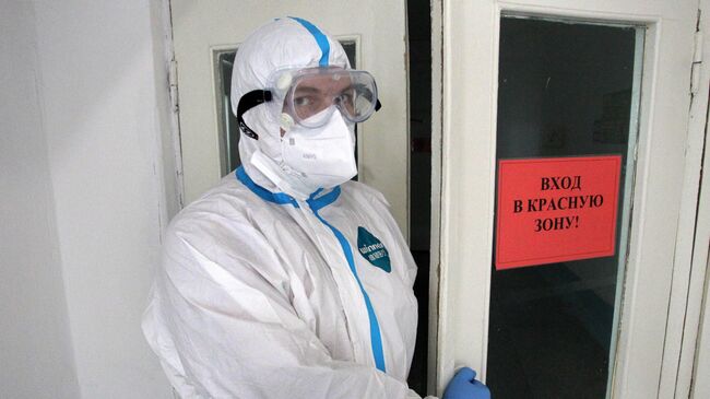 Медицинский работник у входа в красную зону ковид-госпиталя в Новоалтайске