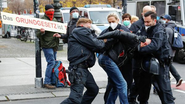 Полицейские задерживают участника протестов у здания бундестага в Берлине