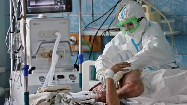 Медицинский работник и пациент в отделении интенсивной терапии ковид-госпиталя