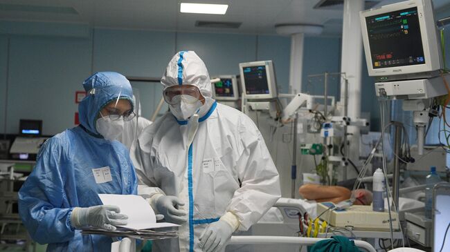 Медицинские работники и пациент в отделении интенсивной терапии ковид-госпиталя