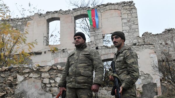 Военнослужащие у разрушенного здания в Физулинском районе Азербайджана