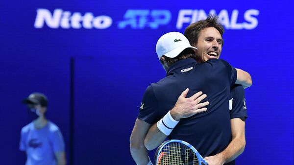 France's Edouard Roger-Vasselin (R) and Austria's Jurgen Melzer (front) embrace after winnning the match against Australia's John Peers and New Zealand's Michael Venus in their men's doubles round-robin match on day four of the ATP World Tour Finals tennis tournament at the O2 Arena in London on November 18, 2020. (Photo by Glyn KIRK / AFP)