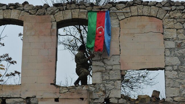 Военнослужащие у разрушенного здания военного комиссариата в Физули